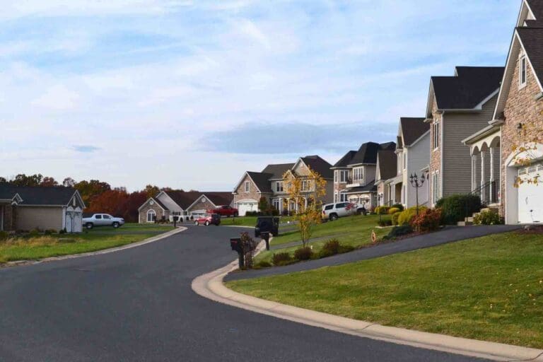 Suburban neighborhood street view of multiple houses at sunset